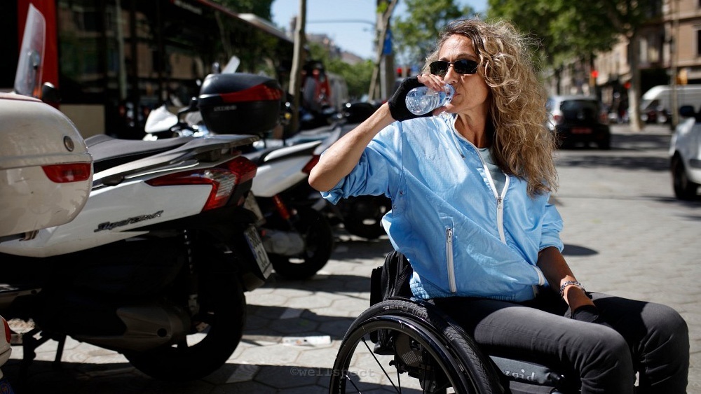 Woman in wheelchair drinks water
